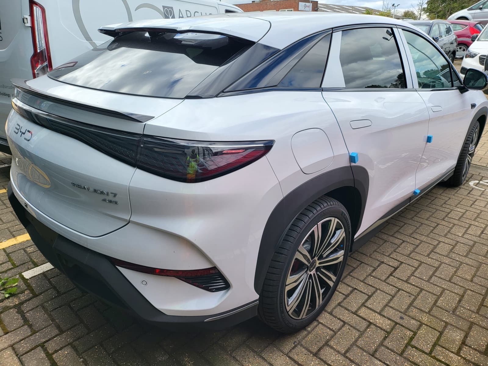 White crossover SUV, rear three-quarter view